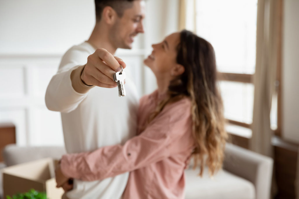 un jeune couple heureux avec des clés d'une maison