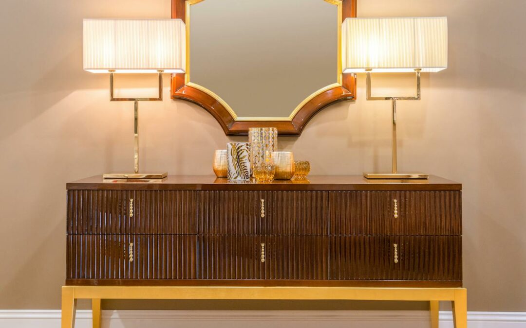 Un buffet élégant en bois massif surmonté d'un grand miroir doré et de deux lampes de table design dans un intérieur raffiné